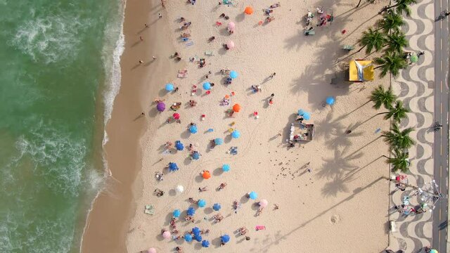 Rio de Janeiro, Brazil, top down aerial view of waves breaking on the shore of famous Copacabana beach during summer. 