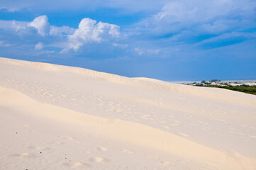 View of dunes with blue sky and clouds in the background in Araranguá , Santa Catarina