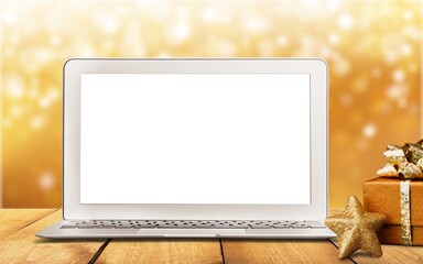 Blank screen on laptop computer Merry Christmas table background. Xmas online