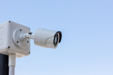Security CCTV camera surveillance system outdoor of house. A blurred night city scape background. Modern CCTV camera on a wall. Equipment system service for safety life or asset.