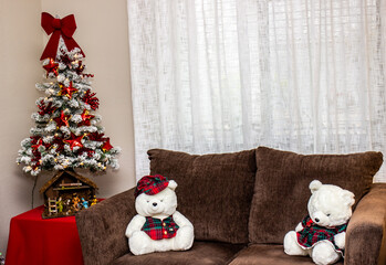 White Teddy Bears Sitting On Love Seat Next To Small Christmas Tree