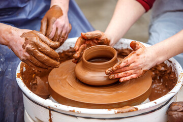 The master of pottery makes dishes from brown clay. Folk art.