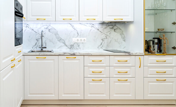 Interior Of Neoclassical Style White And Gold Wooden Kitchen With Island In Luxury Home