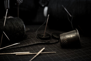 Old retro sewing machine, needle with thread, scissors and thimble. Tailor, seamstress and fashion designer tools for sewing clothes. Handmade