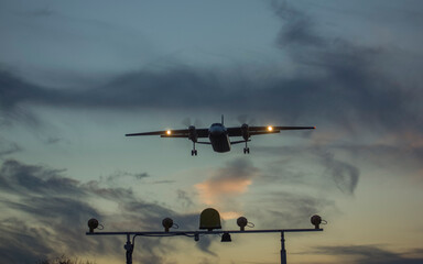 A private jet airliner is landing at sunset
