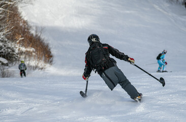 Fototapeta na wymiar Adaptive Skiing with one leg : Disabled ski racer a three-tracker, or one-legged skier training kids how to ski at Stowe mountain resort