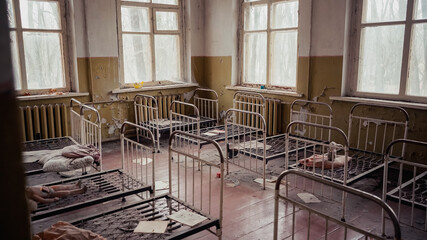 interior of abandoned kindergarten with metal beds in chernobyl exclusion zone.