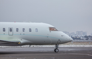 Obraz premium A twin-engine jet plane stands at the airport in the parking lot at winter 