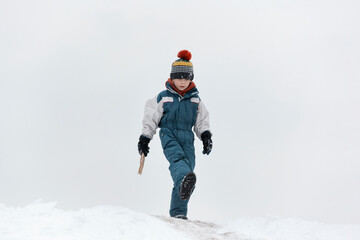 Fototapeta na wymiar Cute boy in warm hat walking in winter Park. Child walks in the snow. Walk outside on cold winter day.