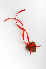 Gingerbread hearts festive on Valentines Day with red ribbon on white background. Vertical frame