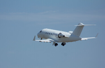 Private white jet plane takes off from the airport against the backdrop of a clear sky during the day