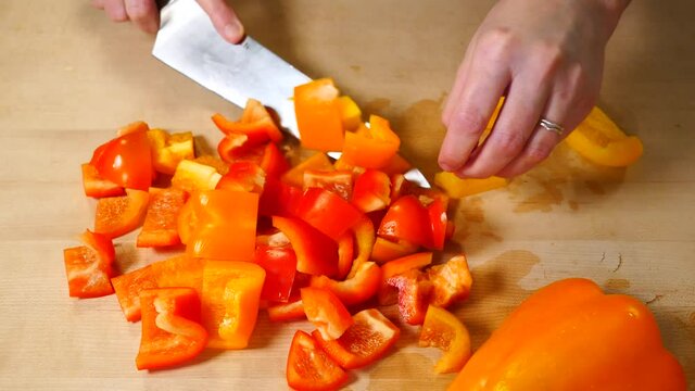 Cutting Orange Red Yellow Pepper on Wooden Cutting Board