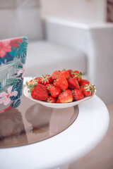 a plate of strawberries on the table in the room