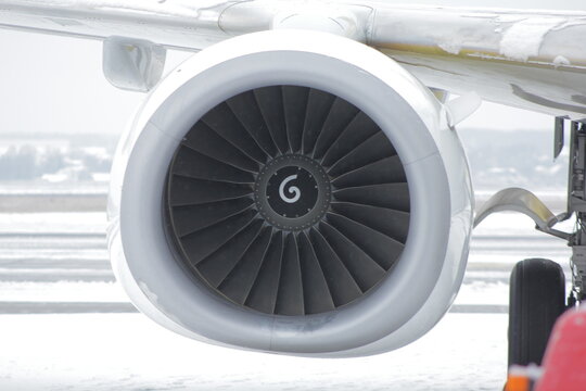 Aircraft jet engine of a liner, turbine blades on the background of the airport in winter