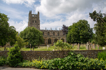 St Mary's Church behind stone wall during summer with blue sky and clouds in the background