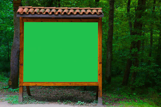 chosen focus. Big empty hollow green sign made of wood in wonderful green color among the trees in Izmit Ormanya	
