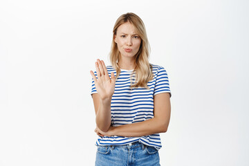 Enough, stop it. Serious woman looking concerned, showing palm, hand warning gesture, blocking...
