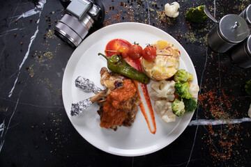 Served on plate with chicken legs and vegetables