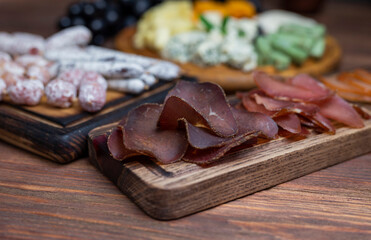 assorted dor blue cheese with mozzarella meat jamon with grapes on a wooden board