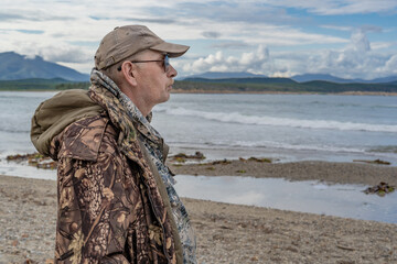 Portrait of a pensive elderly man on the seashore, looking to the side.thinking about the meaning of life