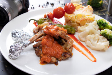 Close-up of two grilled chicken legs and vegetables in a grill pan. horizontal view from above