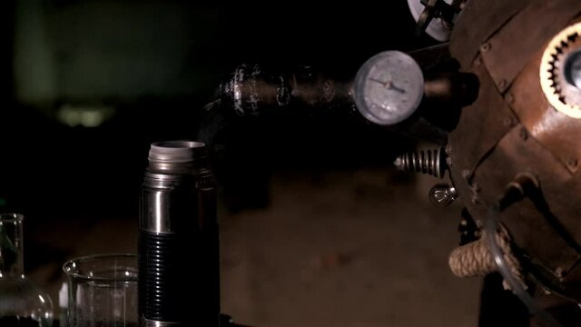 Masculine hands pour liquid nitrogen from the dewar vessel into a thermos. Super slow motion. The concept of alchemy. Steampunk