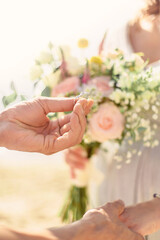 Fototapeta na wymiar delicate wedding bouquet in the hands of the bride in summer