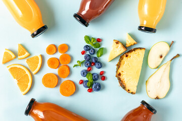 Flat lay various fresh juices from fruit, berries and vegetables in bottles on blue background, top...