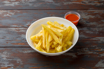 French fries with ketchup sauce on wooden table
