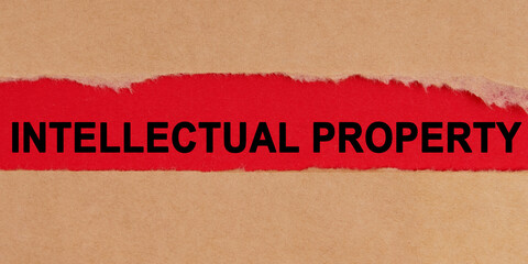 Among the torn sheets of paper on a red background, the inscription - intellectual property