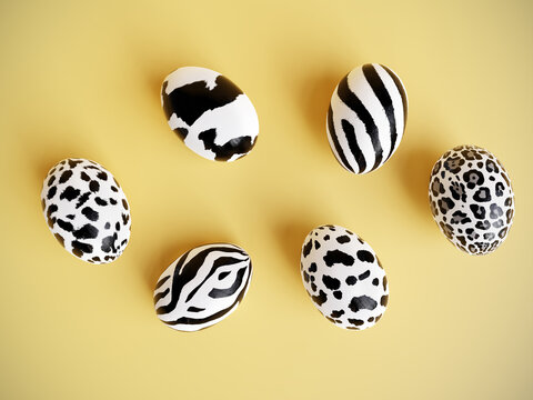 Six Easter eggs with animal skin pattern on yellow background