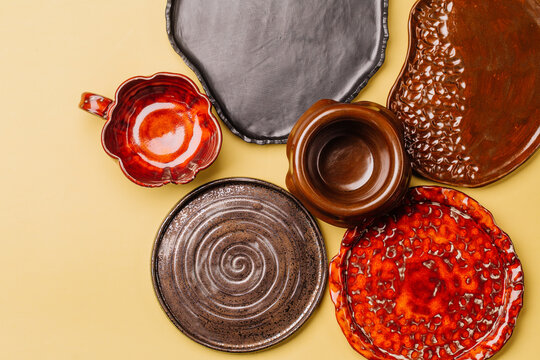 Composition from a handmade different plates on yellow background. Top view, horizontal image