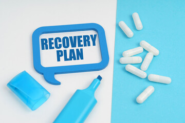On the white and blue surface are a marker, tablets and a plate inside which the inscription - RECOVERY PLAN