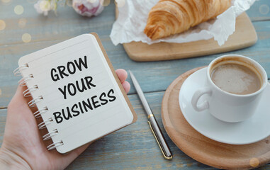 Grow your business words on office table with computer, coffee, notepad, smartphone