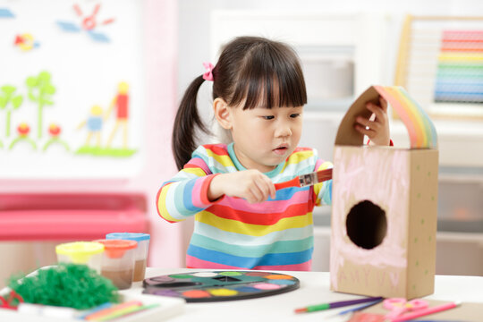 young girl making bird hourse craft for home schooling