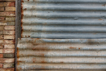 background texture of rusty roof sheets, bricks and wood