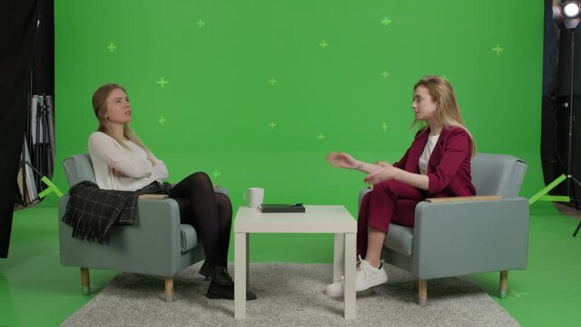 Young female patient and woman psychologist at psychotherapy session over green screen background. Youth talk show interview with a famous guest