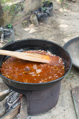 Large pot of Nigerian stew and beef, communal cooking 
