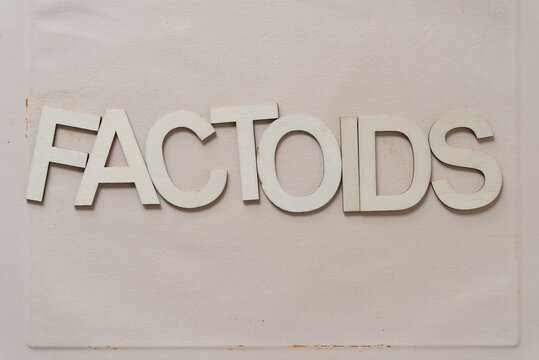 "factoids" in wood type isolated on old paper