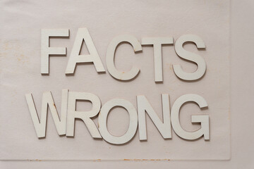 the expression "facts, wrong" in wood type isolated on a wooden surface