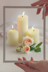 blurry valentine's day background with candle lights,roses.Hands hold the frame near the creative composition. 