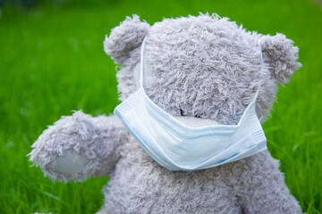 A bear in mask outdoors in park pandemic concept