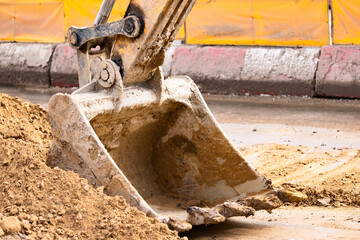 Excavator bucket on the road reconstruction scene