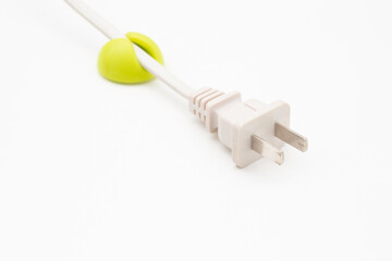 White power plug in a green cable clip