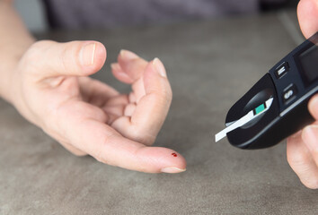 Woman checking her blood sugar to control diabetes and insulin dose after carbs
