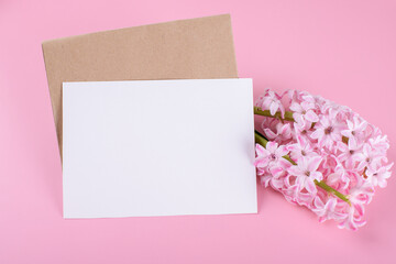 Blank wedding invitation stationery card mockup with envelope on pink background with hyacinth flowers