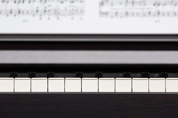 Piano keyboard and sheet music blured