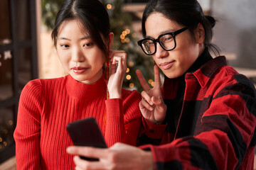 Loving couple gesturing while making selfie at the smartphone