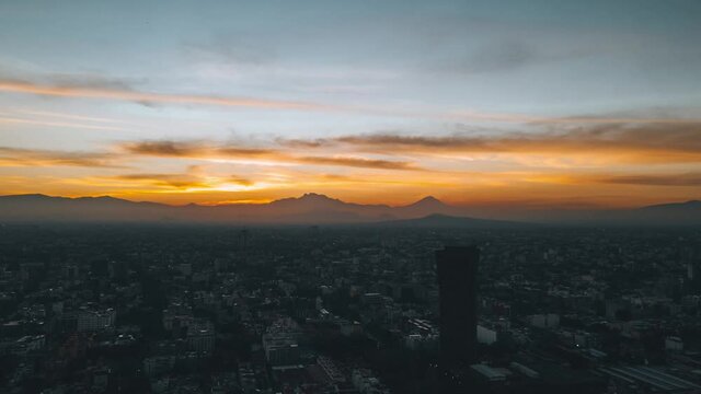 Hyperlapse de amanecer en la Ciudad de M&eacute;xico, cinem&aacute;tica toma a&eacute;rea con drone de amanecer de cielo anaranjado con nubes en el Distrito federal