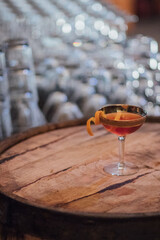 single cocktail on barrel in front of upturned glassware at party